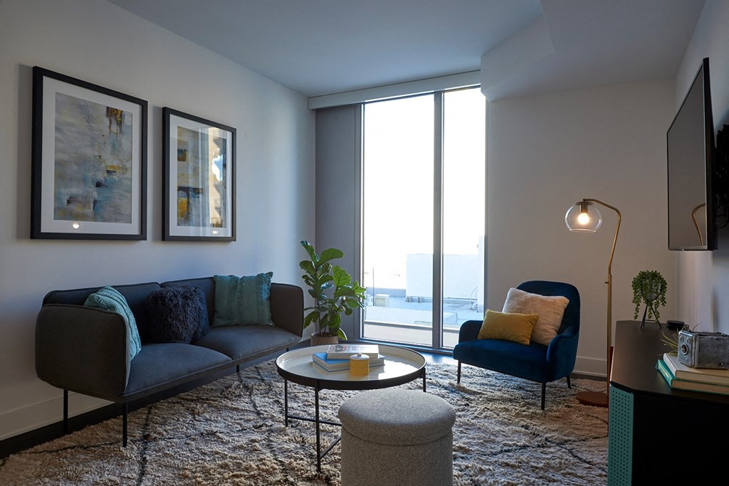 a living room with a couch and chairs and a large window