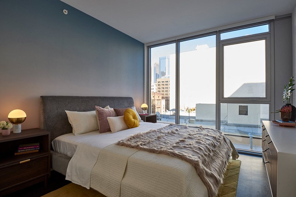 a bedroom with a bed and a large window