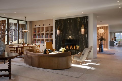 A modern living room with a fireplace and a large bookshelf.