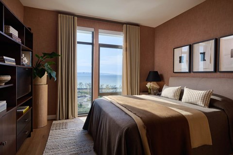 A bedroom with a large bed and a view of the ocean.