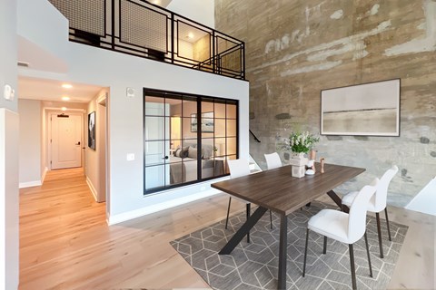 A dining room with a wooden table and white chairs.