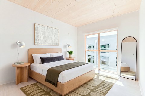 A bedroom with a large bed and a wooden headboard.