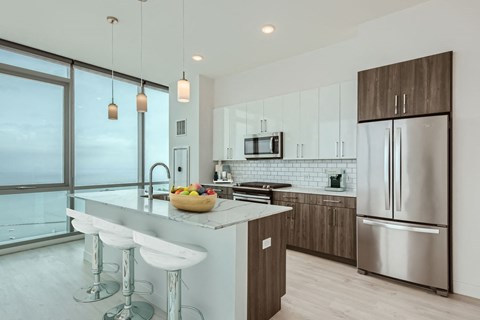 a kitchen with a large island and stainless steel appliances