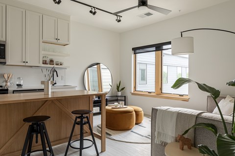 A modern kitchen with wooden cabinets and a bar area.