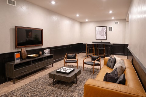 a living room with a couch and chairs and a television