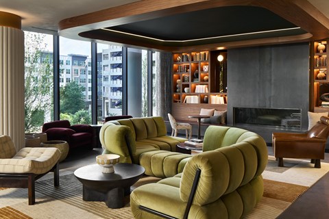 A living room with a green chair in the foreground and a fireplace in the background.