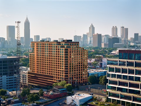 A cityscape with a large orange building in the foreground.