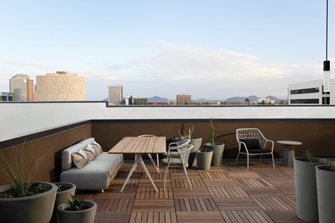 A patio with a table and chairs overlooking a cityscape.