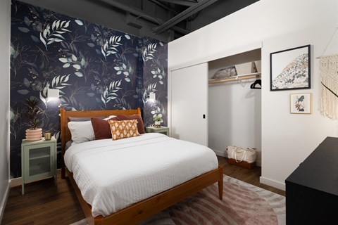 A bedroom with a large bed and a wallpapered wall.