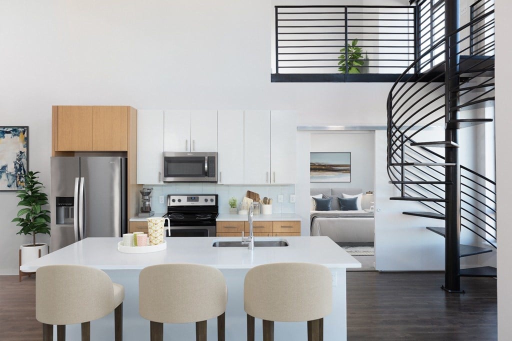 A modern kitchen with a spiral staircase.