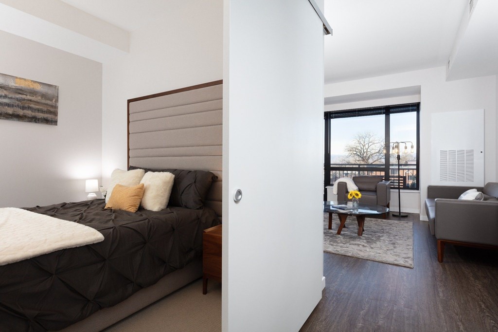 A bedroom with a large bed and a balcony.