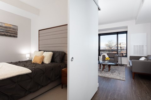 A bedroom with a large bed and a balcony.