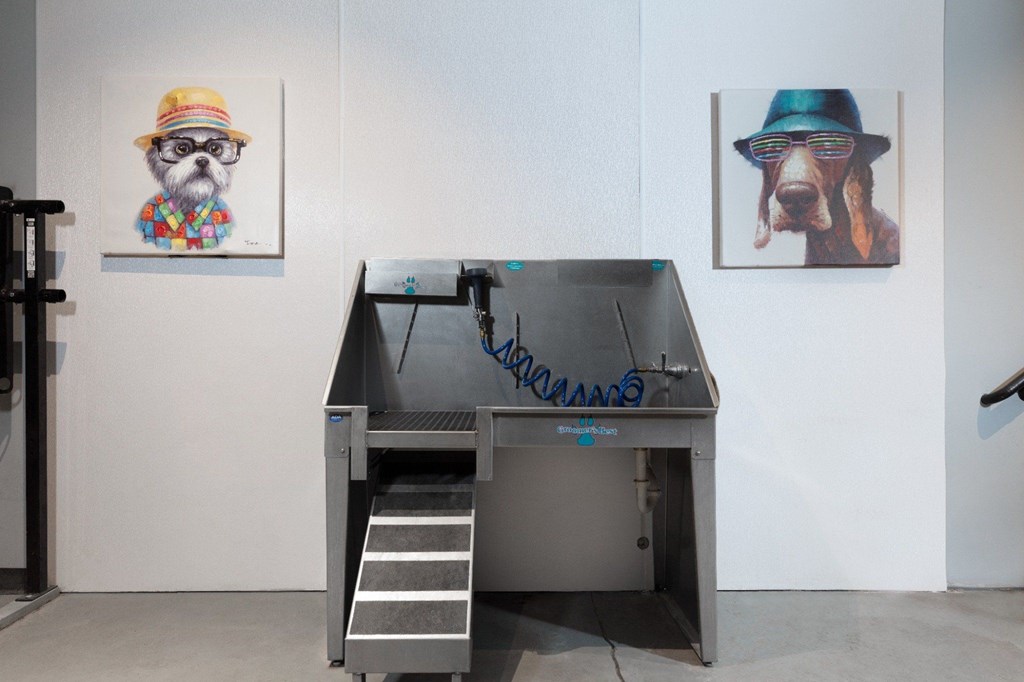 A dog wearing a hat is on a painting behind a machine.