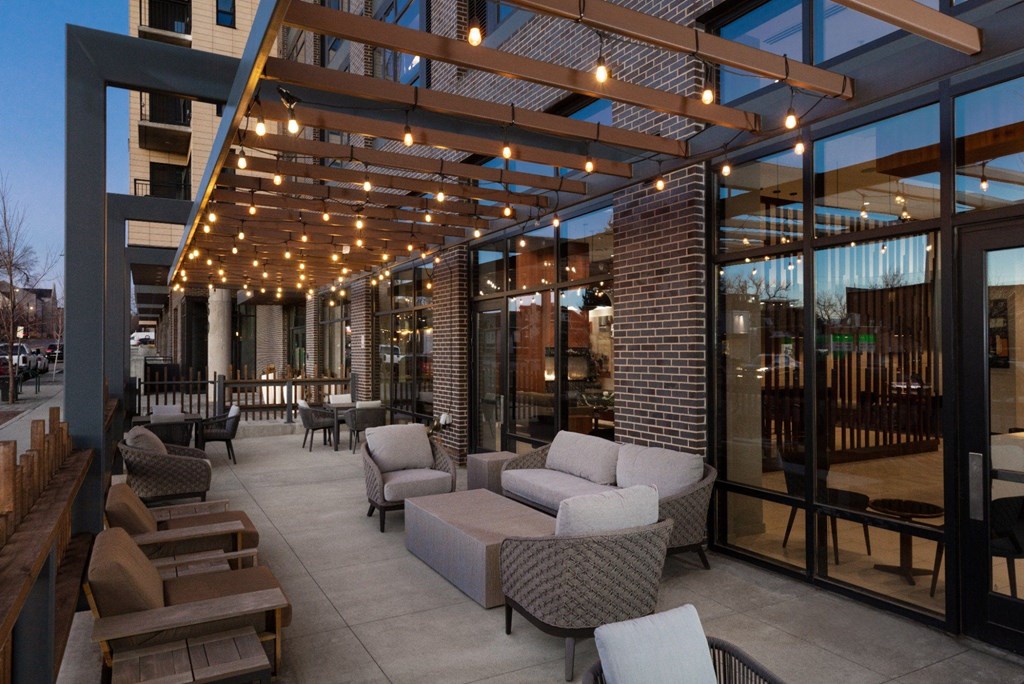 A patio with a lot of furniture and lights.