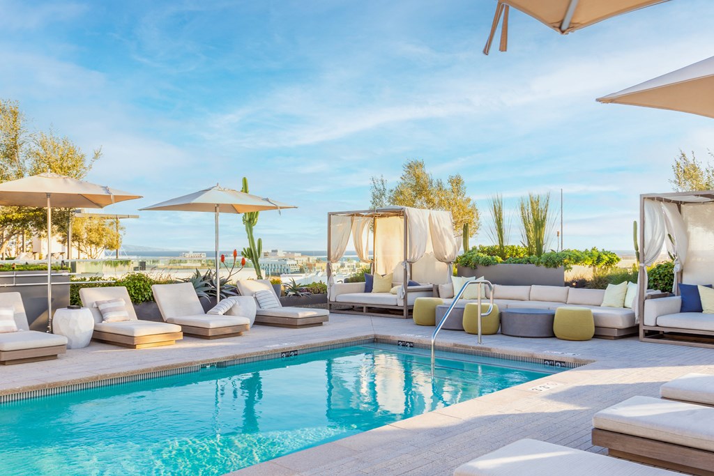 a swimming pool with chaise lounge chairs and umbrellas