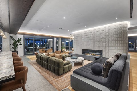 A modern living room with a large sectional sofa and a fireplace.