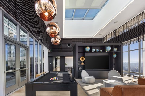 A modern living room with a pool table and a view of the city.