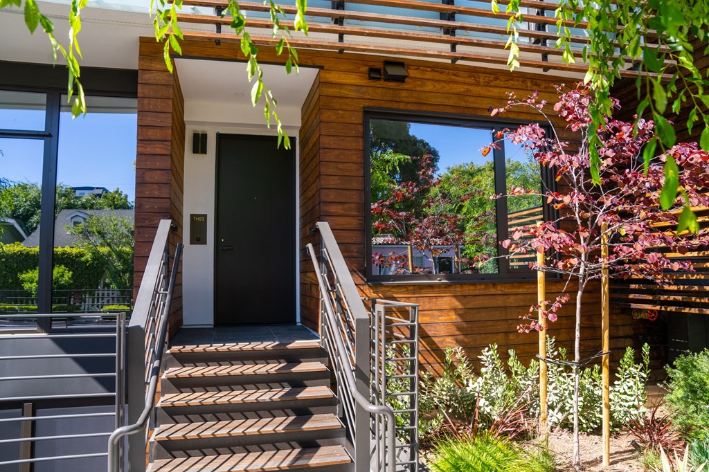 the front of a house with stairs and a front door