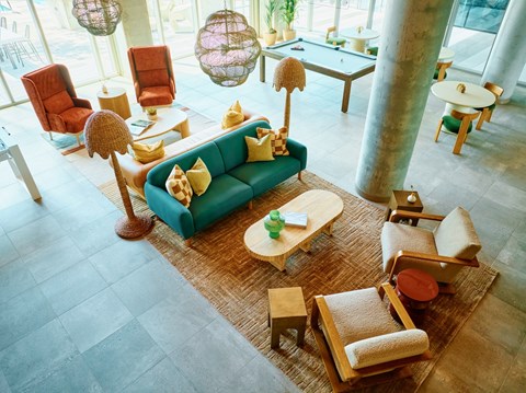 A living room with a blue couch and wooden furniture.
