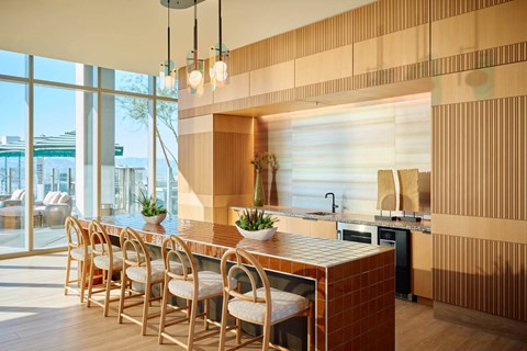 A modern kitchen with wooden chairs and a counter.