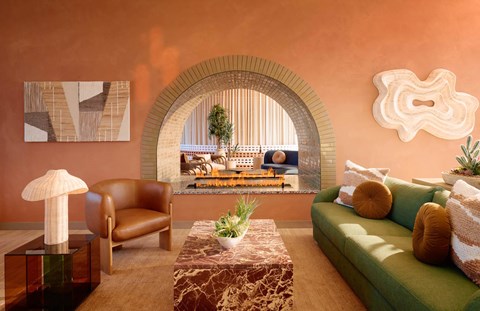 A living room with a green couch and a brown chair.