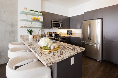 A kitchen with a marble countertop and stainless steel appliances.