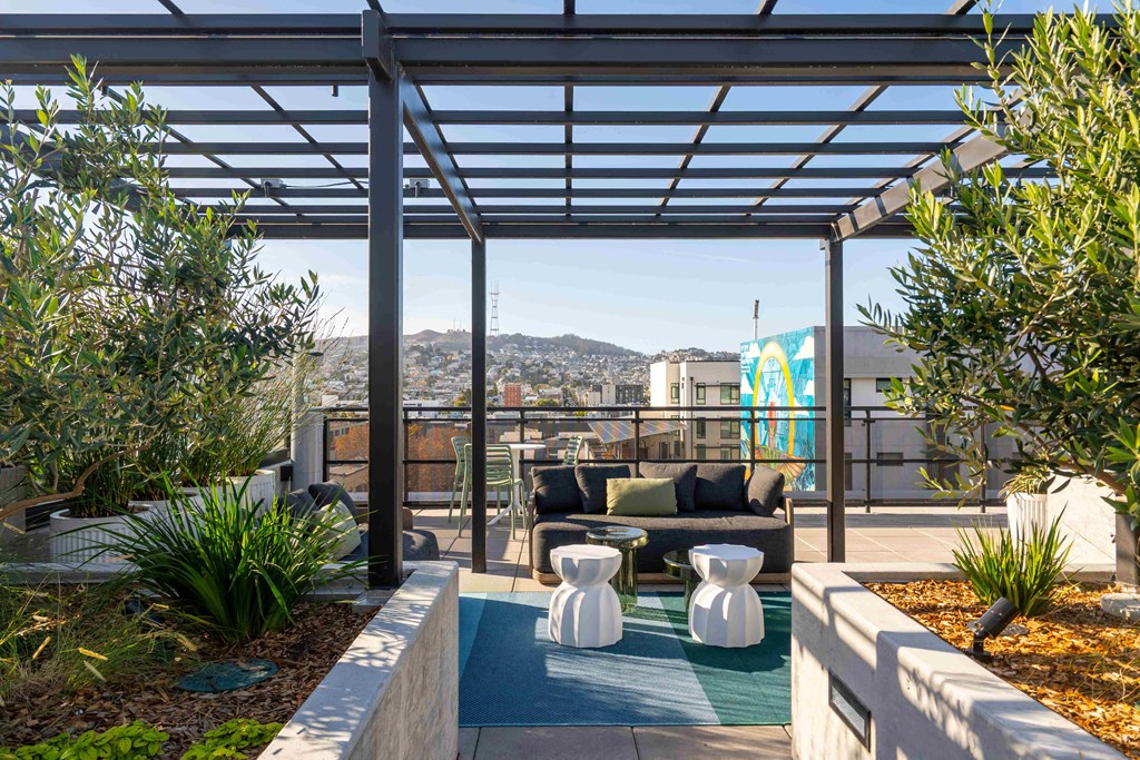 a terrace with a couch and a table under awning