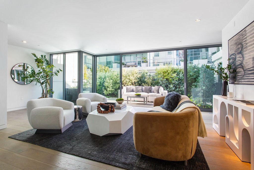a living room filled with furniture and large windows