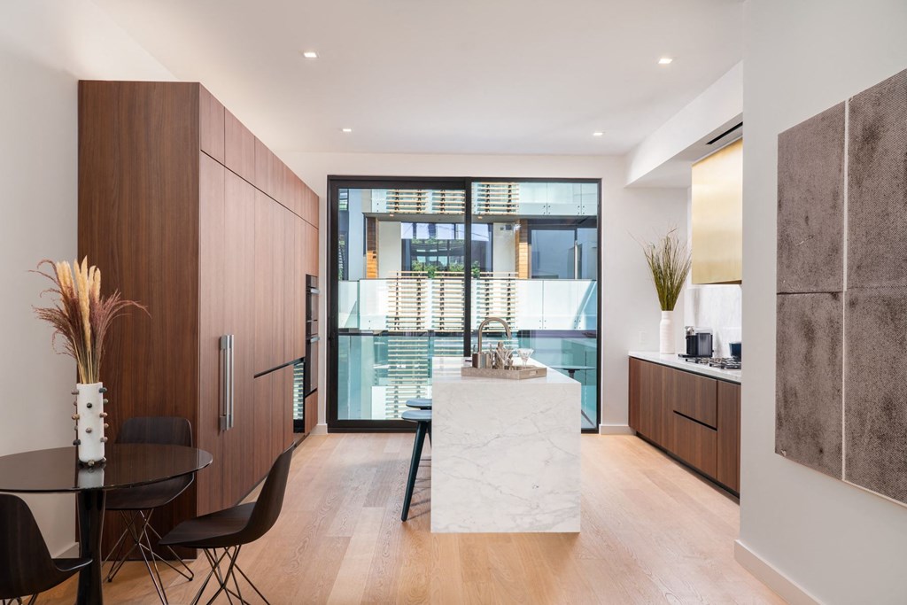 a kitchen and dining room with a marble table and a large window