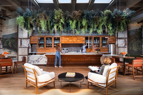 a woman reading a book in the lobby of a hotel bar