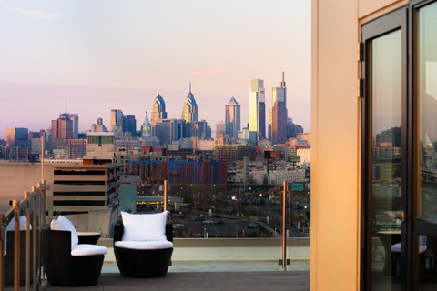 a view of the skyline from a rooftop terrace with two white chairs