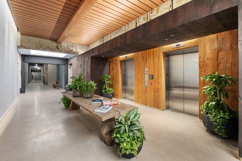 the lobby of a building with a wooden table and plants