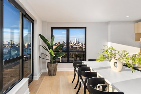 a dining room with a table and chairs and a view of the city