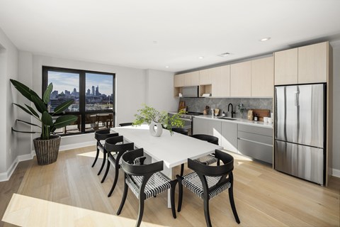 an open kitchen and dining room with a white table and black chairs