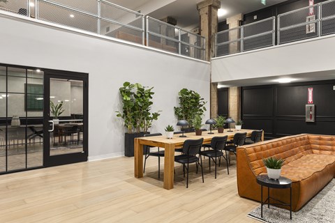a dining area with tables and chairs and a leather couch