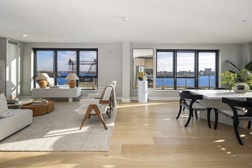 an open living room and dining room with a view of the harbor and the city