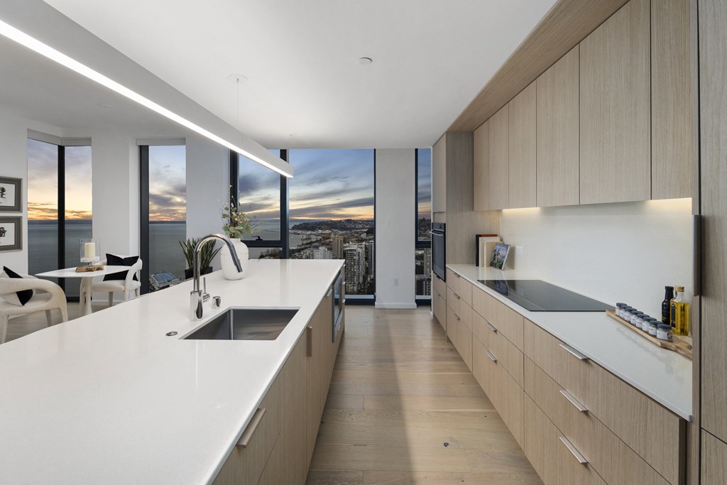 a large kitchen with white countertops and a view of the city