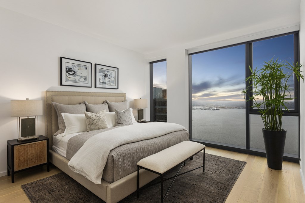 a bedroom with a bed and a large window overlooking a body of water