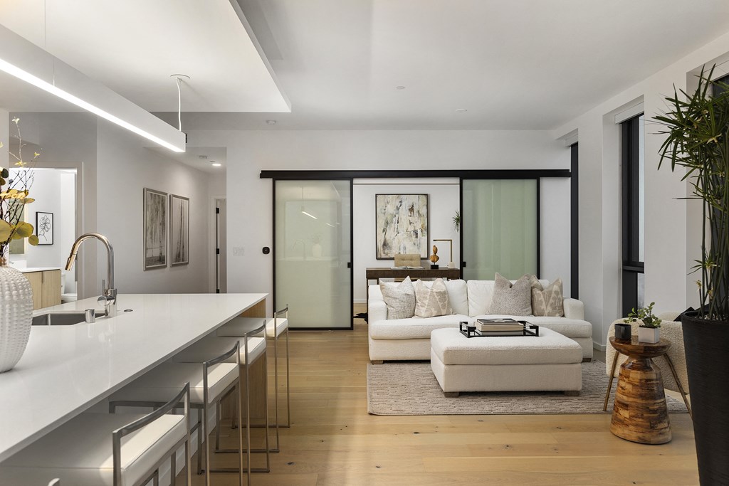 a living room with a white couch and a bar and a kitchen