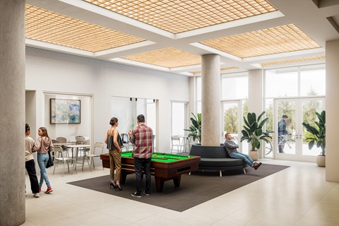 A group of people are gathered in a room with a pool table.