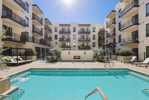 A swimming pool in front of apartment buildings.