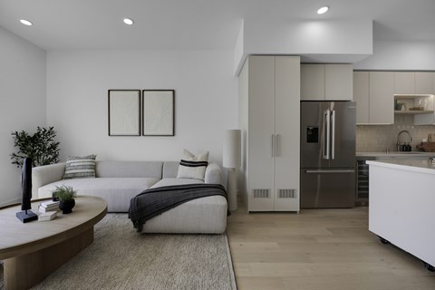 A modern living room with a grey sofa and a black and white picture on the wall.