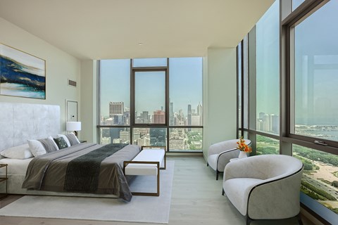 a bedroom with a bed and a large window     and a couch