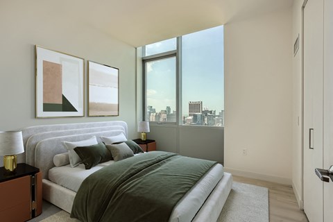 a bedroom with a bed and a large window