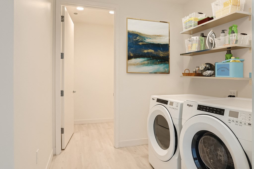 a washer and dryer in a laundry room with a door to a bathroom