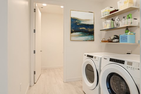 a washer and dryer in a laundry room with a door to a bathroom