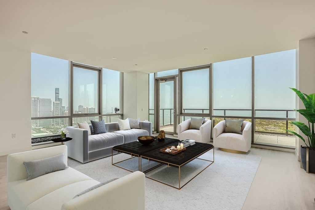 a living room with white couches and a coffee table in front of windows