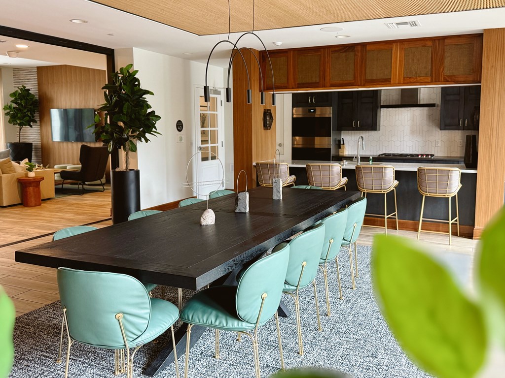A modern dining room with a long table and chairs.