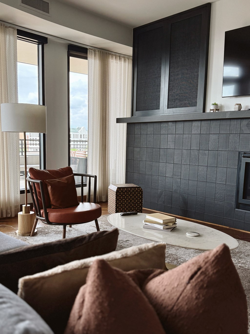 A living room with a red chair and a grey rug.