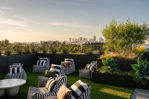 A patio with black and white striped cushions and a view of the city skyline.